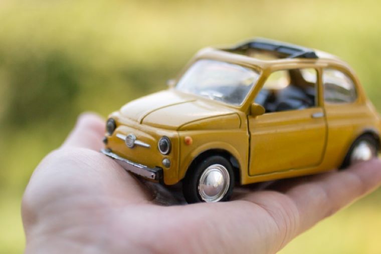 愛車のミニカーを持つ人